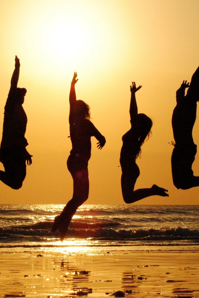 Sonnentanz einer Gruppe am Strand, um wieder Kraft  zu schöpfen für neue berufliche agile Projekte.